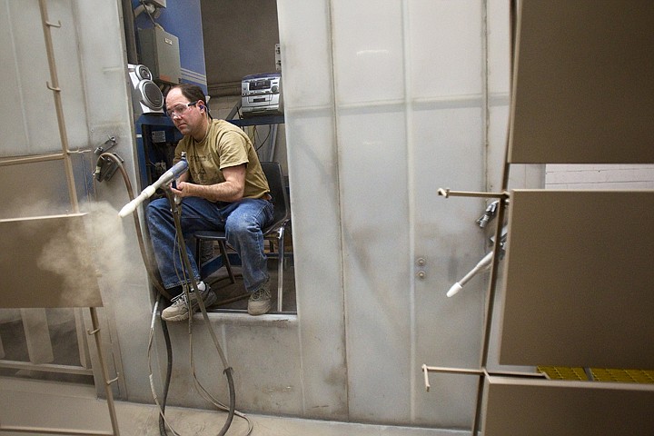 &lt;p&gt;Terry Wigen, powder coat operator for Kimball Office in Post Falls, sprays office cabinet parts during his shift on Monday. The manufacturer has eliminated the need for liquid paint, reducing the amount of hazardous waste by thousands of barrels over the past several years.&lt;/p&gt;