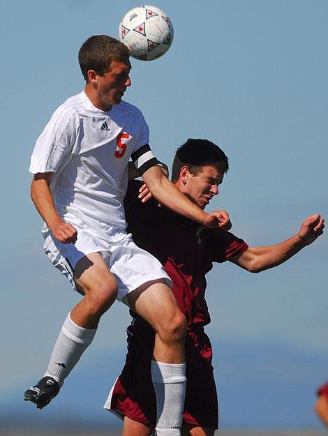 Flathead High School senior forward Cameron Clevidence (5) heads the ball over Helena High midfielder Ben Hills during a soccer match at Kidsports Complex in Kalispell, Saturday. Clevidence scored one goal and assisted on a second as Flathead won, 2-1. Garrett Cheen/Daily Inter Lake