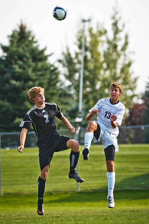 <p>SHAWN GUST/Press Alec Johnson (13) of Lake City kicks the ball away as Coeur d'Alene's Adam Borsheim nearly collides with the action.</p>