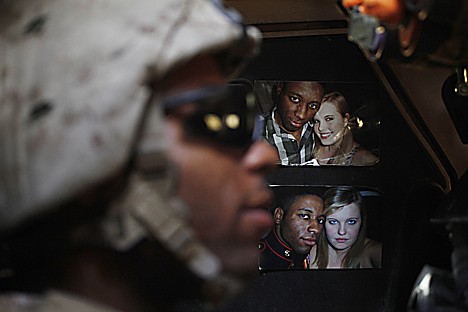 &lt;p&gt;In this Aug. 20 photo, a U.S. Marine rides inside an armored vehicle with taped-up pictures of his wife, in Helmand province, southern Afghanistan. Young men share an intensity of experience on a deployment which is often difficult to communicate to loved ones, who may find it impossible to comprehend. AP Photo/Brennan Linsley&lt;/p&gt;