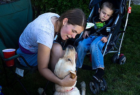 &lt;p&gt;Debra Ackerman pets their new dog Silas center with her son Luke Ackerman at their welcome party for Silas on Saturday afternoon. Silas was trained for two years to become an assistance dog through Canine Companions for Independence.&lt;/p&gt;