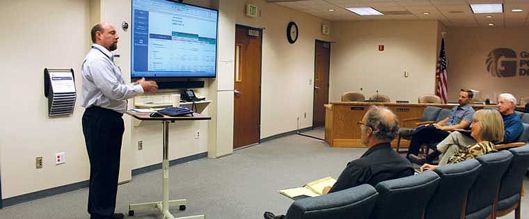Jeremy Nolan (standing) explains the process used to conduct a cost of service analysis for the Grant County PUD.