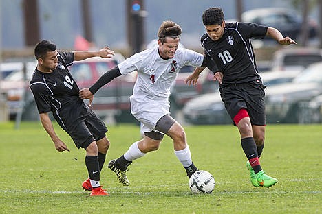 &lt;p&gt;North Idaho College senior forward Chris Wheelock, center, powers through Columbia Basin College&#146;s Cesar Garcia, left, and Lorenzo Isiordia Wednesday at North Idaho College.&lt;/p&gt;