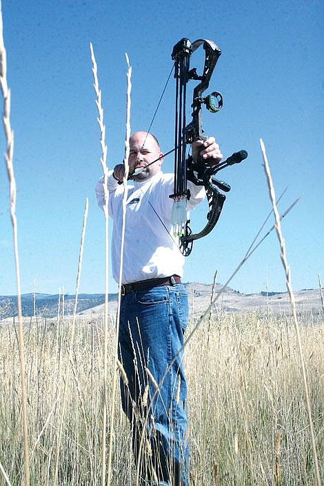 Jason Shueh/Valley Press Archer Jerrod Lyle, the manager at Trophy Taker, aims his compound bow outside the shop.