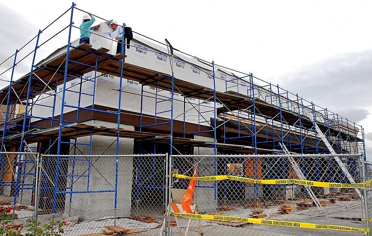 Ivan Shelko, left, works with his father Ivan Shelko Sr. to weatherize a building under construction at Hutton Ranch Plaza in Kalispell Thursday afternoon. The 5,600-square foot building is listed for lease by Scott Strellnauer with Glacier Sotheby&#146;s International Realty. Strellnauer said he&#146;s nearing the end of negotiations with a retail client to lease the space. He expects the deal to wrap up within a few weeks. Strellnauer said inquiries by retail customers have increased significantly in the last few months compared to a year ago.