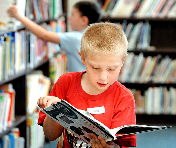 Micha Campbell, a first grader at Russell Elementary School selects a book about the Titanic on Wednesday. Yesterday was Montana Library Day.