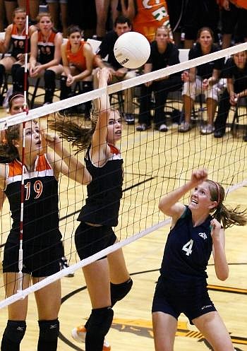 Glacier's Rachel Cutler (4) keeps her eye on the ball after her hit was blocked by Flathead's Cassie Krueger (19) and Kwyn Johnson at the net Thursday evening at Flathead. Nate Chute/Daily Inter Lake