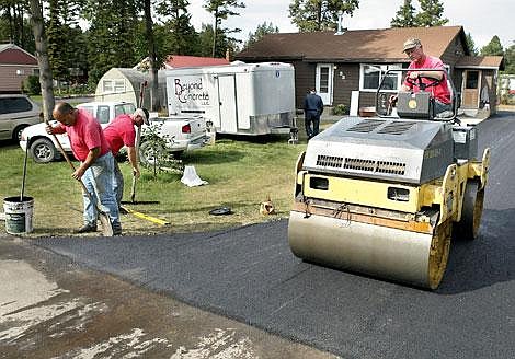 Scott Faraone, left, and Monte Huntington of T-Bend Construction put the finishing touches Friday on a new driveway at the home of Brandon Nielsen in Evergreen. Over the last week volunteers brought together by Becky's parents, Gary and Jane Hall, have been overhauling Nielsen's home and will surprise him when he returns this weekend. Craig Moore/Daily Inter Lake