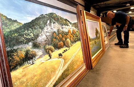 Jim Meyer, with Bigfork Quick Response Unit, sets up several original oil paintings at Gardner Auction on Tuesday, which are scheduled to be auctioned off at 7 p.m. Thursday. The paintings, along with 200 other items, were donated to the Bigfork Community Foundation Trust by the Ed and Pat Box estate in Bigfork. Paintings, sculptures and household goods are just some of the items being auctioned off Thursday night. Garrett Cheen photos/Daily Inter Lake