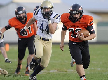 <p>Flathead's Payton Boyce outruns Big Sky's Travis Crawford during the Braves' homecoming game at Legends Stadium on Friday. (Aaric Bryan/Daily Inter Lake)</p>