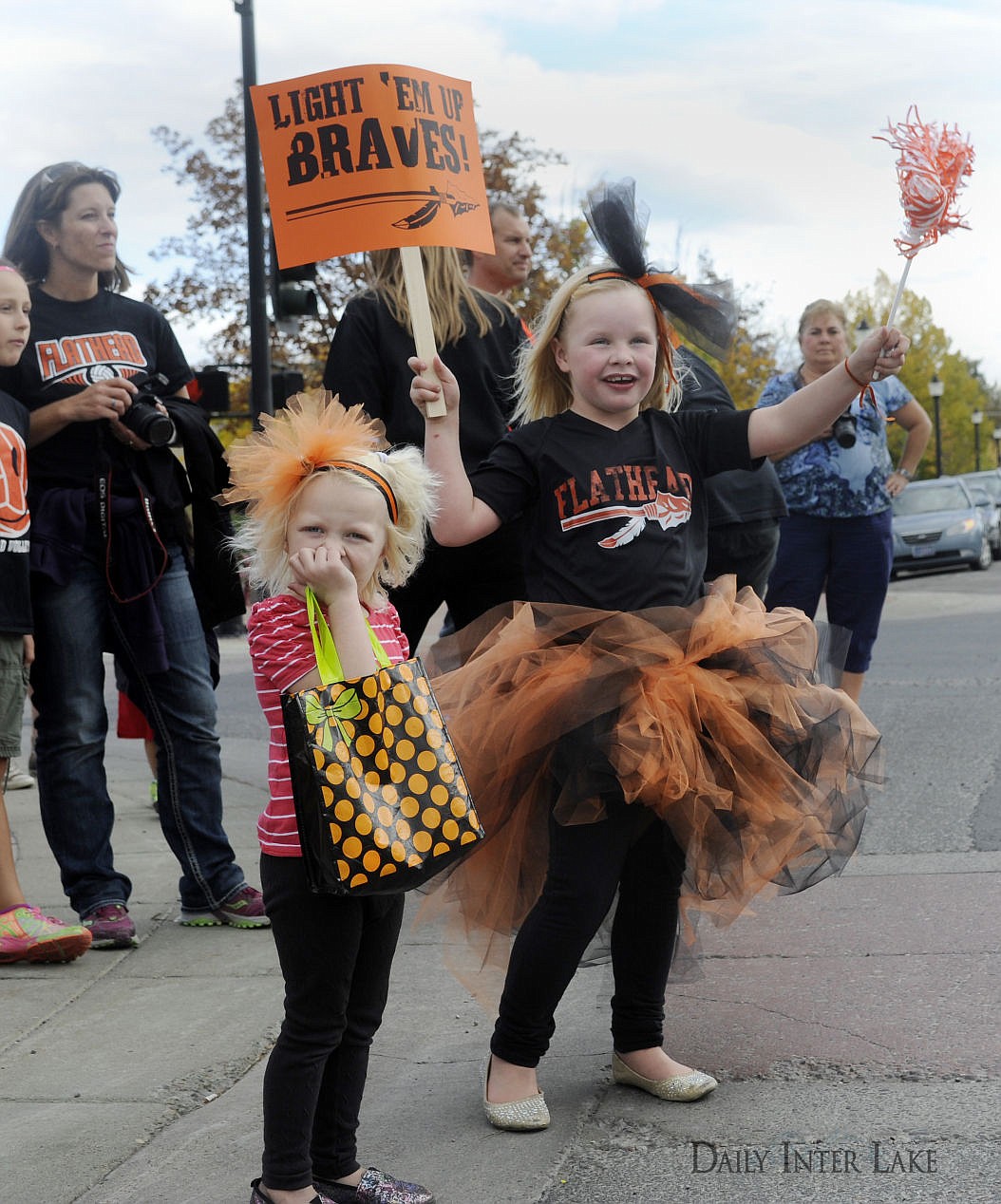 <p>Molly, left, and Mallory Leigh cheer on the Flathead High School homecoming parade in Kalispell on Friday. (Aaric Bryan/Daily Inter Lake)</p>