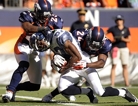 &lt;p&gt;Seattle Seahawks wide receiver Ben Obomanu (87) is tackled by Denver Broncos' Renaldo Hill (23) and Champ Bailey (24) as he crosses the goal line for a touchdown during the second half Sunday in Denver.&lt;/p&gt;