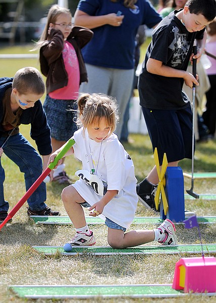<p>Bailey Ulrick, 5, of Kalispell, works her way through the
miniature golf course on Saturday afternoon at the 14th Annual
Pete's Fall Fest at Peterson School in Kalispell. Ulrick also
competed in the one mile run and took second place in the 6 and
under category.</p>