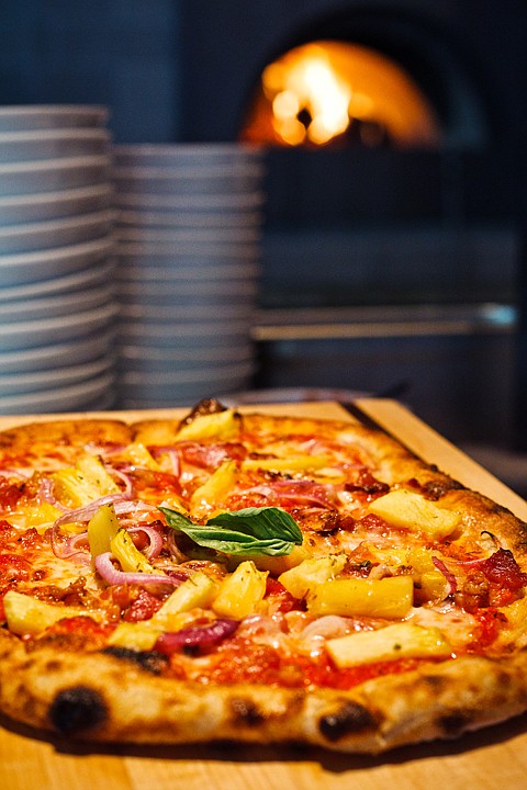 <p>SHAWN GUST/Press A single basil leaf finishes Fire's Tuesday special, a pancetta and fresh pineapple with red onion pizza.</p>