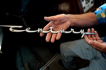 <p>Mason Niblack shows off the original Century logo for the 1960's Utility boat the "Never More" which he is currently restoring. The restoration was begun by Lou and Bill Borchers from whom Niblack acquired the boat.</p>
