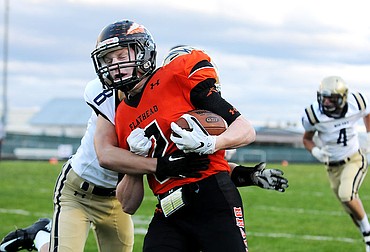 <p>Flathead's Seth Adolph carries Missoula's Big Sky's Tyler Glenn in the end zone to start the scoring for the Braves at Legends Stadium on Friday. (Aaric Bryan/Daily Inter Lake)</p>