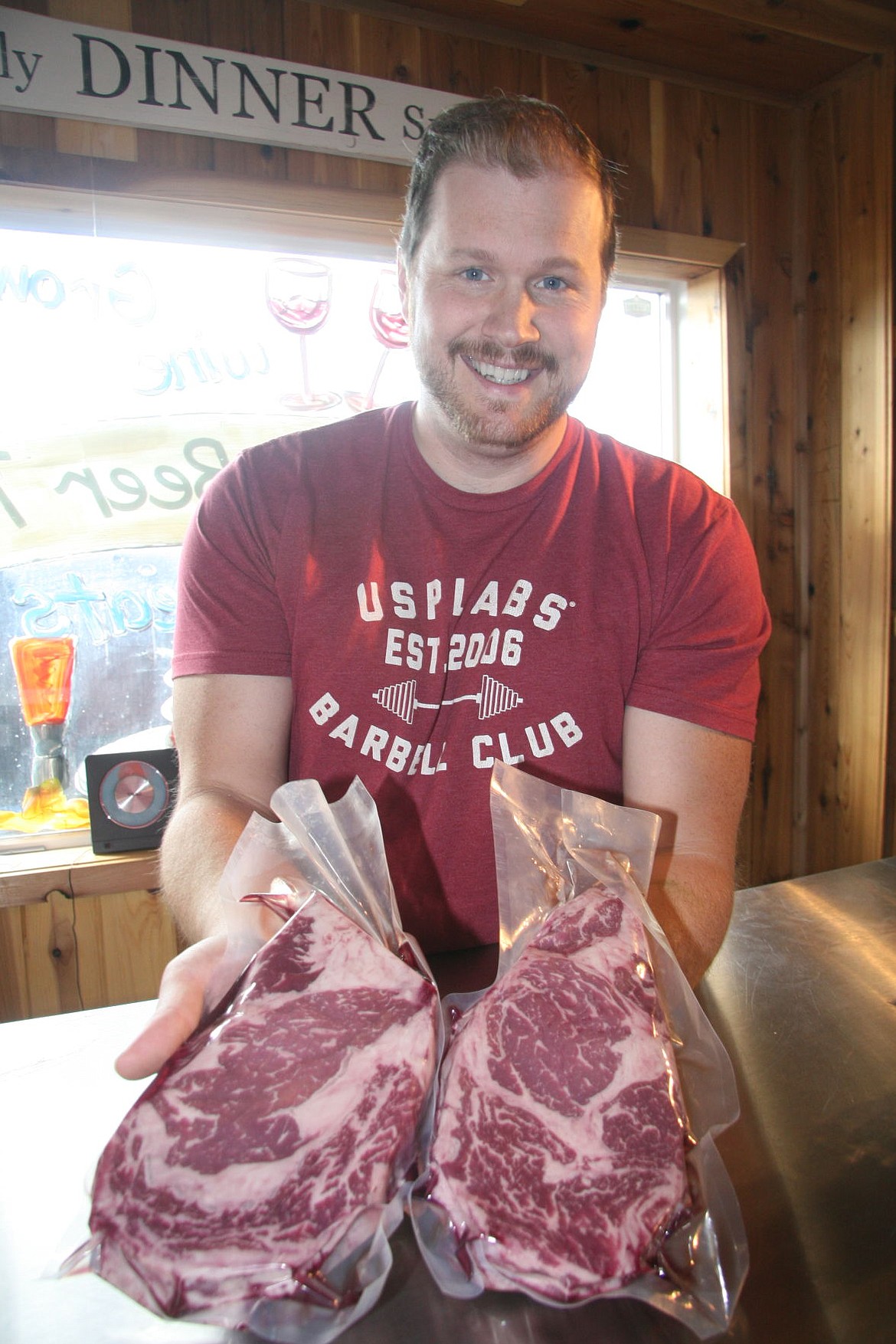 Alex Hoover, store manager of Heritage Meats &amp; More shows off some locally sourced steaks.