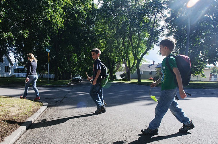 &lt;p&gt;Shanda Elavsky walks her sons Chase, center, and Tristan home from Russell Elementary School on Thursday afternoon. Elavsky is concerned about the lack of sidewalks on the streets between Russell Elementary and her home on Third Avenue East North.&lt;/p&gt;