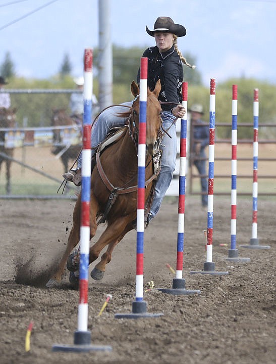 &lt;p&gt;Devi Knutson leans away from a pole as she competes in high school rodeo in Polson on Saturday.&lt;/p&gt;