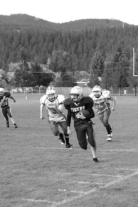 Nick Ianniello/Mineral Independent Noxon players Tyrell Wilkinson, left, and Bryant Eaton, right, chase St. Regis Tiger Willy Roper to a touchdown at their junior varsity game in St. Regis Monday night.