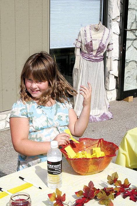 Jason Shueh/Valley Press Ashlynn Meckler, age 8, grabs a yellow card from the prize drawing bowl to announce the winner of a new book donated by Waldenbooks in Missoula.