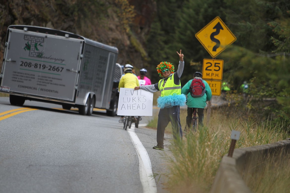 &lt;p&gt;DEVIN HEILMAN/Press&lt;/p&gt;&lt;p&gt;Frank Garcia of Coeur d'Alene &quot;warns&quot; cyclists that &quot;evil lurks ahead&quot; as they trek up the hill at Beauty Bay. Garcia and several volunteers joined Bill Robinson and his Bloomsday Vulture to make the Coeur d'Fondo even more fun for participants.&lt;/p&gt;