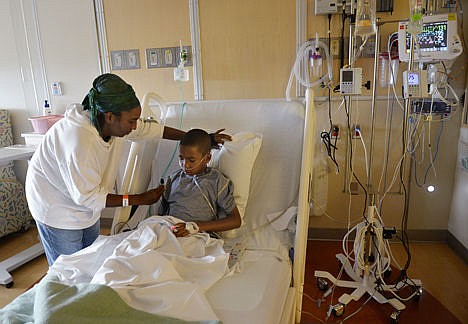 &lt;p&gt;In this Sept. 8 photo, Melissa Lewis, of Denver, helps her son, Jayden Broadway, 9, as he coughs in his bed at the Children's Hospital Colorado in Aurora, Colo. He was treated for the enterovirus 68 and released, but his asthma made the illness more difficult to fight. The CDC is investigating nine cases of muscle weakness or paralysis in children at the hospital and whether the culprit might be enterovirus 68 which is causing severe respiratory illness across the country.&lt;/p&gt;