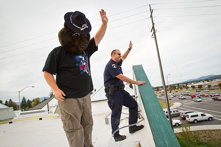 &lt;p&gt;SHAWN GUST/Press Special Needs Recreation Olympics athlete Kirk Grogan, of Rathdrum, and trooper Allen Ashby, with the Idaho State Police, wave at passers-by Friday from the roof of Texas Roadhouse in Coeur d'Alene as part of an overnight fundraising effort called Cop on Top. Donations will continue to be accepted today at the restaurant from 10:30 a.m. to 11:00 p.m.&lt;/p&gt;