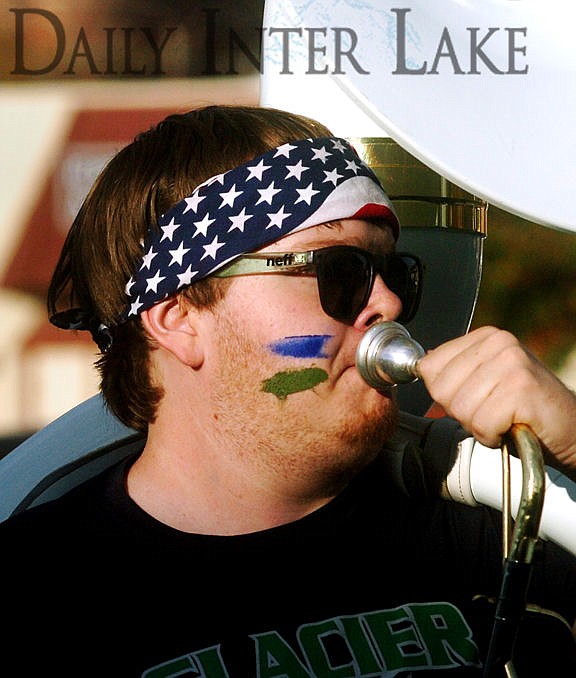 <p>Paul Bruce plays the sousaphone as he marches with the band during Glacier's homecoming parade. (Aaric Bryan/Daily Inter Lake)</p>