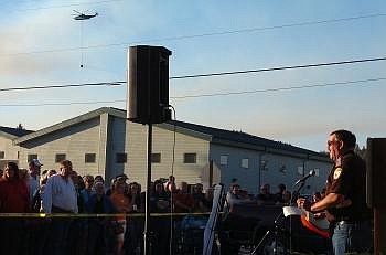 Flathead County Sheriff Mike Meehan addresses a crowd of approximately 150 people during a public meeting outside the Lakeside Community Chapel as a helicopter circles back toward the fire to drop a bucketload of water from Flathead Lake.