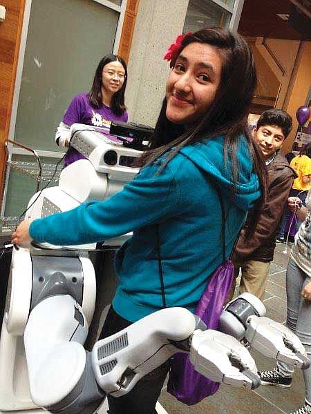 Kasandra Edeza gets a hug from an innovative robot. This robot also likes to give high fives.