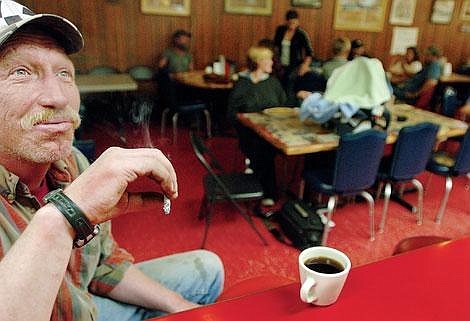 Tim Schmidt of Kalispell smokes a cigarette Wednesday in the Sykes' restaurant. Sykes' is one of many local businesses that will be forced by state law to become nonsmoking establishments on Saturday. &quot;I think that businesses should be able to make their own decisions about whether or not people can smoke inside,&quot; Schmidt said. &quot;I'm trying to smoke extra this week because I know that next week it's all over.&quot; According to his friend Gary Neagles of Kalispell, &quot;It seems like they're just legislating morality. Why is it the government's job to tell us if we can or can't smoke?&quot; Chris Jordan/Daily Inter Lake