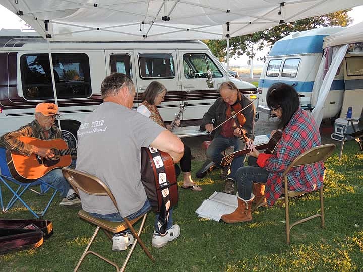 Fiddler Donnie Oberg and a few friends gather at a camping site for a jam session in the George Community Park.