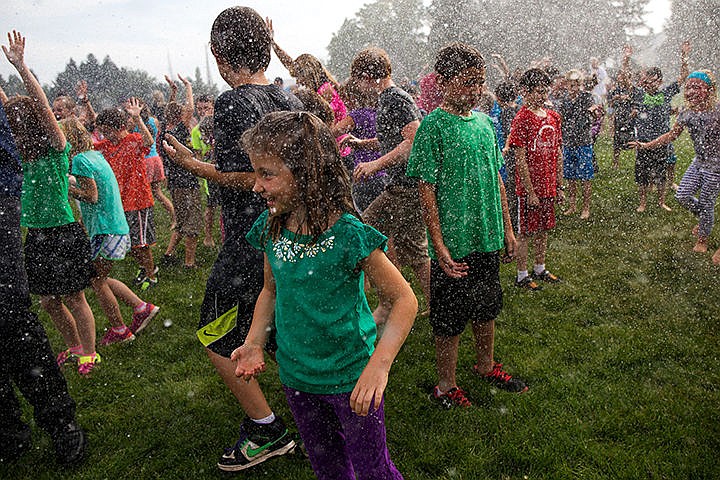 &lt;p&gt;TESS FREEMAN/Press&lt;/p&gt;&lt;p&gt;Kinsey Burke, 8, center, smiles as she is sprayed by Kootenai County Fire Department during Dalton Elementary School&#146;s ALS ice bucket challenge on Tuesday afternoon. Dalton Elementary School raised $575 to donate for ALS research and challenge Hayden Meadows Elementary School to complete the ice bucket challenge. &#160;&lt;/p&gt;
