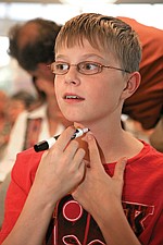 Alex Salois, 13, of Polson draws a dot where you would insert a cricothyrotomy tube to bypass a choking victim.