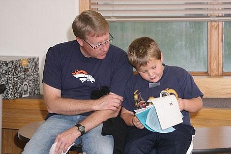 Nick Ianniello/Mineral Independent Steve Carty looks over his son Aaron&#146;s spelling test at an open house at the St. Regis School Wednesday. Parents visited with teachers and other community members.