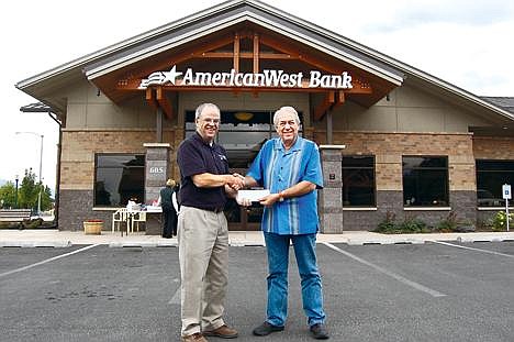 Tom Harvill, left, presents a $2,500 donation to Curt Hagan of the Idaho Panhandle Habitat for Humanity. The donation was given by AmericanWest Bank in celebration of Harvill&#146;s 60th birthday. (Photo by DAVID KEYES)