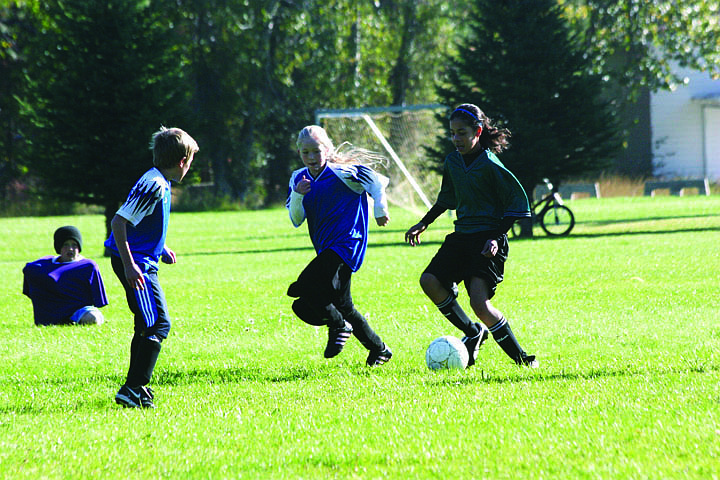 Superior players Blaine Parkin and Hailey Kelly try to team up on Justine Jones from St. Regis as she takes the ball down the field.