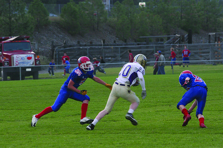 Two Bobcat defenders close in to take down a player from Cut Bank as he tries to take the ball down field. The Bobcats ended up losing the homecoming game.