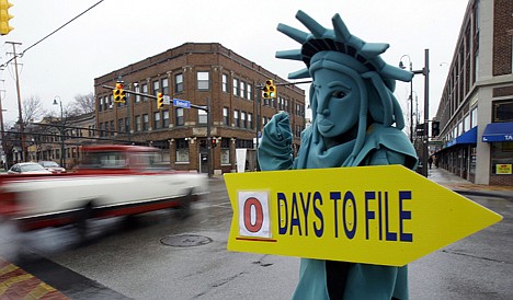 &lt;p&gt;Max Martinez, dressed as the Statue of Liberty, tries to catch motorists' attention on April 18, 2011, the final day to file taxes that year. A typical middle-income family making $40,000 to $64,000 a year could see its taxes go up by $2,000 in 2013 if lawmakers fail to renew a lengthy roster of tax cuts set to expire at the end of 2012, according to a new report issued Monday.&lt;/p&gt;