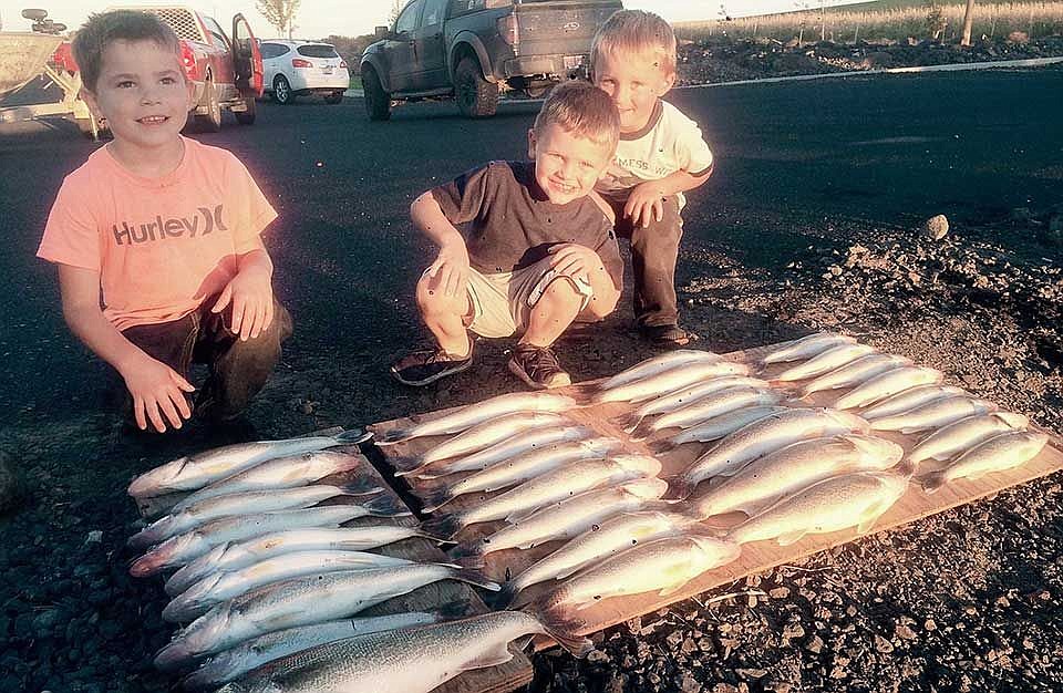 Brit Wardenaar, Grady Stewart and Mason Meseberg stand with their and their and their dad's catch of the day. Love to see the kiddos enjoy the sport of fishing.