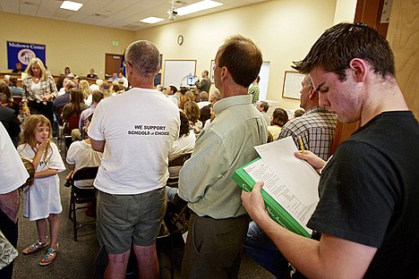 &lt;p&gt;Kyle Jackson, 17, a Coeur d'Alene High student, reads the agenda for the Coeur d'Alene School District board meeting Monday where a review of the PYP Program was reviewed in front of a standing-room only crowd at the Midtown Center.&lt;/p&gt;