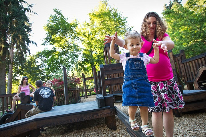 &lt;p&gt;Jill Scieffer offers some support as Annabelle Gould, 1, walks along a balance beam Friday at Fort Sherman Playground in Coeur d'Alene City Park.&lt;/p&gt;