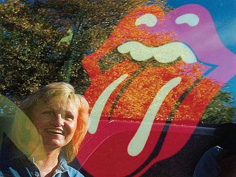 Karen Burkett is reflected in the window of her Chevy Avalanche where she has taped up a Rolling Stones logo. &#147;If tattoos had been in vogue when I was 20, I would have a tongue somewhere, I tell you,&#148; she says of the lips-and-tongue symbol. The Stones are her favorite band, and she has traveled all around the country to see the group. She won&#146;t have to travel far for this tour &#151; the Stones play in Missoula on Wednesday and Burkett, along with several other Flathead Valley fans, will be there. Chris Jordan/Daily Inter Lake