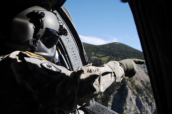 Sgt. Rob Curry keeps a watchful eye open as the Black Hawk flies over the Mission Mountains on Saturday.