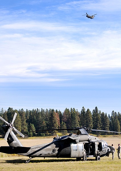 The crew of one of the Black Hawks watches as the Chinock, the final of the three helicopters to arrive, begins to descend toward the Armed Forces Reserve Center in Kalispell on Saturday.
