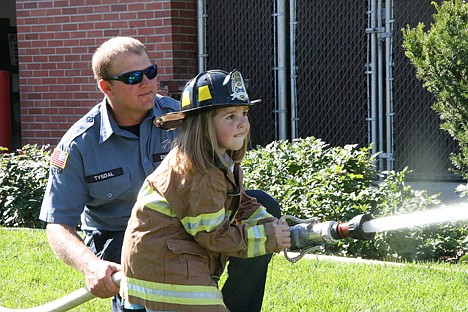 &lt;p&gt;Kadee Greif, 5, sprays a fire hose during the Coeur d'Alene Fire Department's open house on Saturday. Engineer Dave Tysdal helps out behind her.&lt;/p&gt;