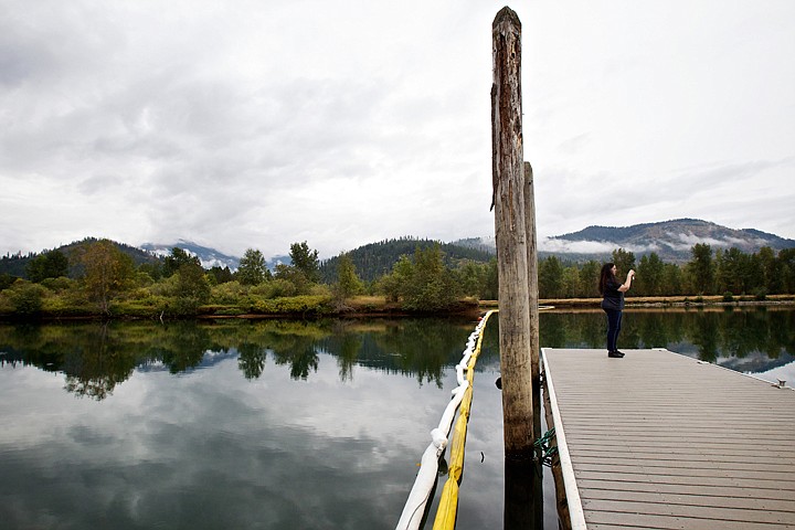 &lt;p&gt;JEROME A. POLLOS/Press Cheryl Landes, from Seattle, takes pictures of the Coeur d'Alene River from a dock Wednesday near the Cataldo Mission as a boom stretches across the water's surface. The barrier was put in place after a drop in pressure was detected for an oil pipeline that traverses the area.&lt;/p&gt;