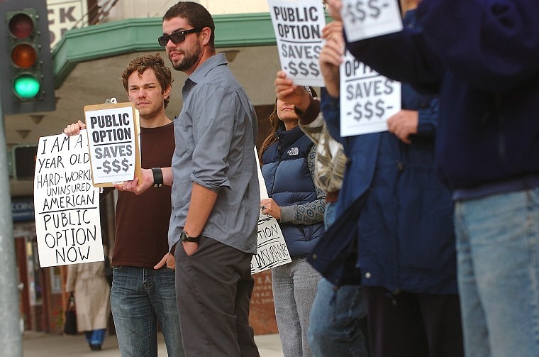 Adam Pitman, left, and C.J. Cummings stand with demonstrators on Main Street in downtown Kalispell on Thursday afternoon. The group was protesting the opposition of Sen. Max Baucus, D-Mont., to a public option for health insurance.