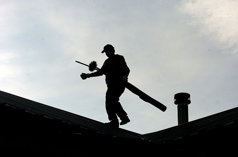 Chimney sweep Dave Fern, owner/operator of Chimney Solutions, makes his way across a roof in Whitefish on Thursday morning.